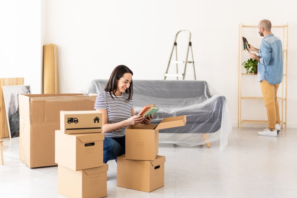 Happy young married couple moving in new home - Relocation concept